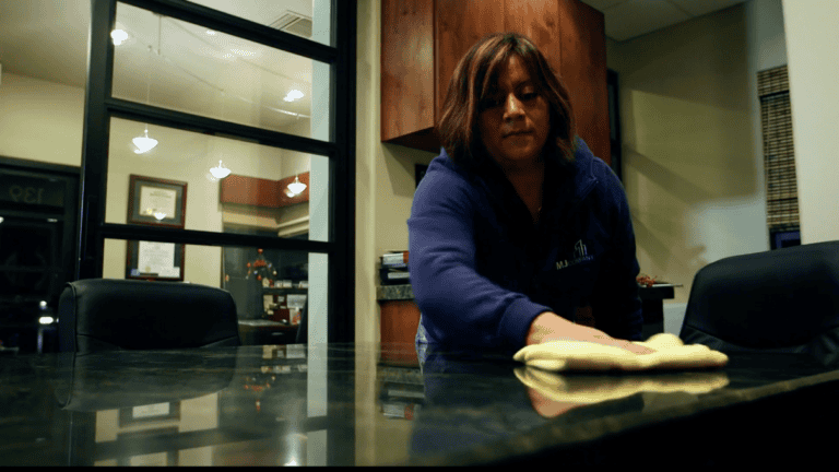 Professional woman cleaning office table as part of commercial cleaning services in Phoenix, AZ