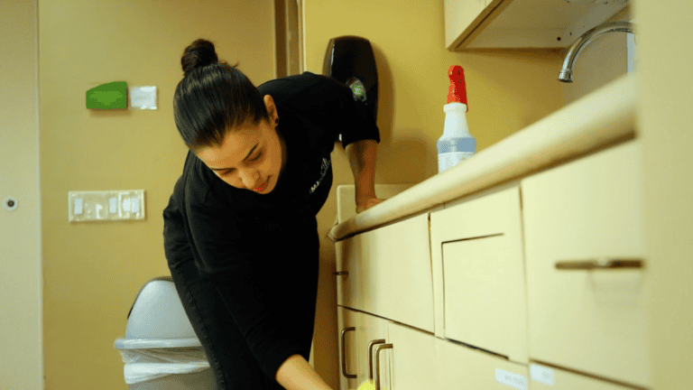 Woman wiping kitchen area during commercial cleaning services in Phoenix, AZ